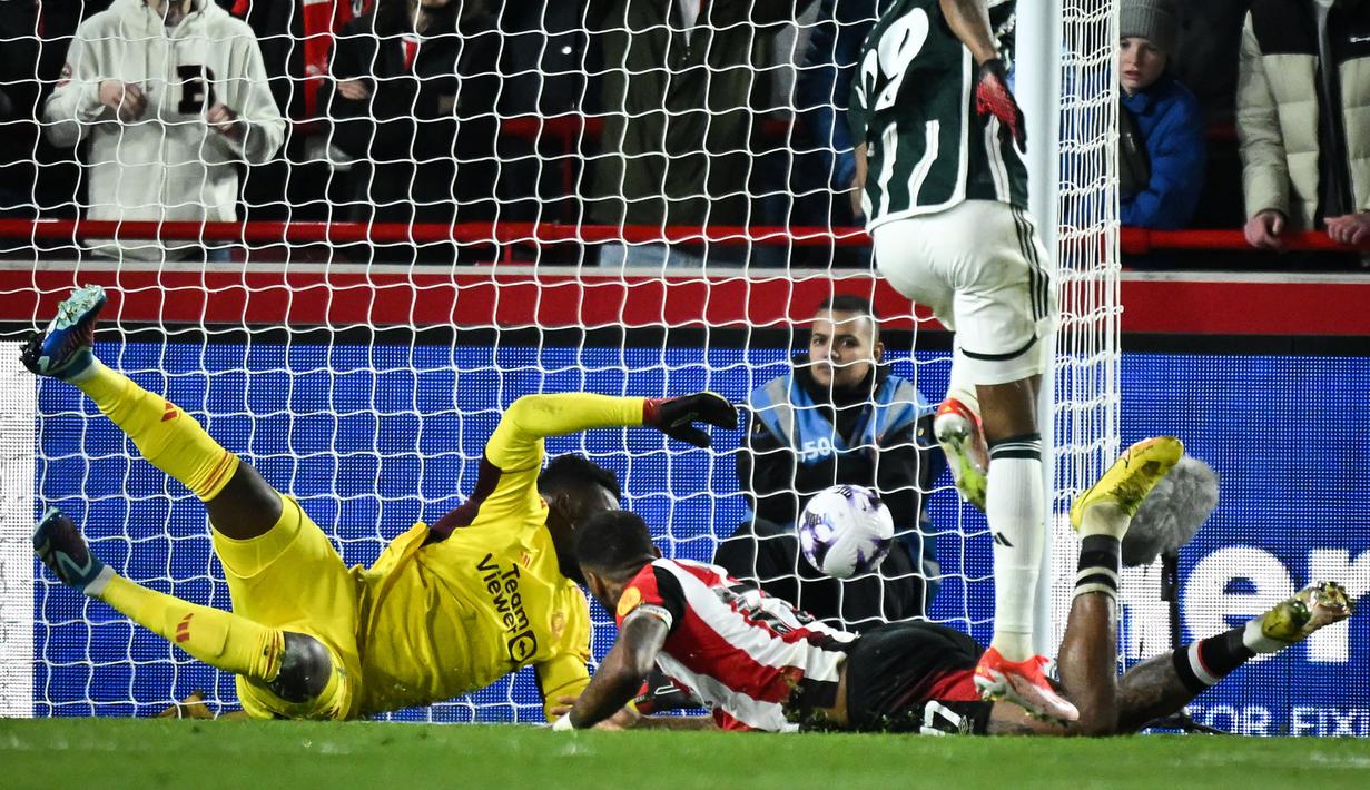 Striker Brentford, Ivan Toney (kanan bawah) mencetak gol ke gawang Manchester United yang akhirnya dianulir VAR karena terlebih dahulu terperangkap offside pada laga pekan ke-30 Premier League 2023/2024 di Gtech Community Stadium, London, Sabtu (30/3/2024). (AFP/Justin Tallis)