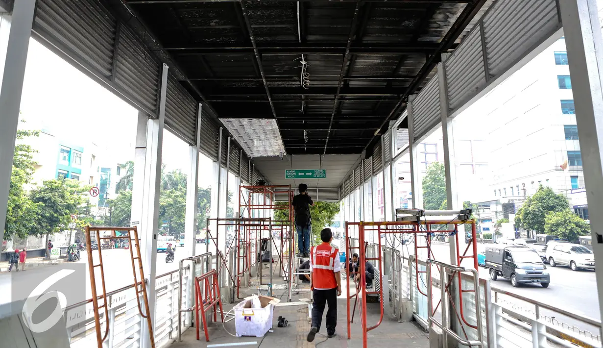 Pekerja menyelesaikan perbaikan halte transjakarta yang terbakar di Salemba, Jakarta, Selasa (7/7/2015). Halte tersebut rusak parah sebagai imbas dari terbakarnya bus Transjakarta koridor 5 pada hari Jumat (3/7) lalu. (Liputan6.com/Faizal Fanani)