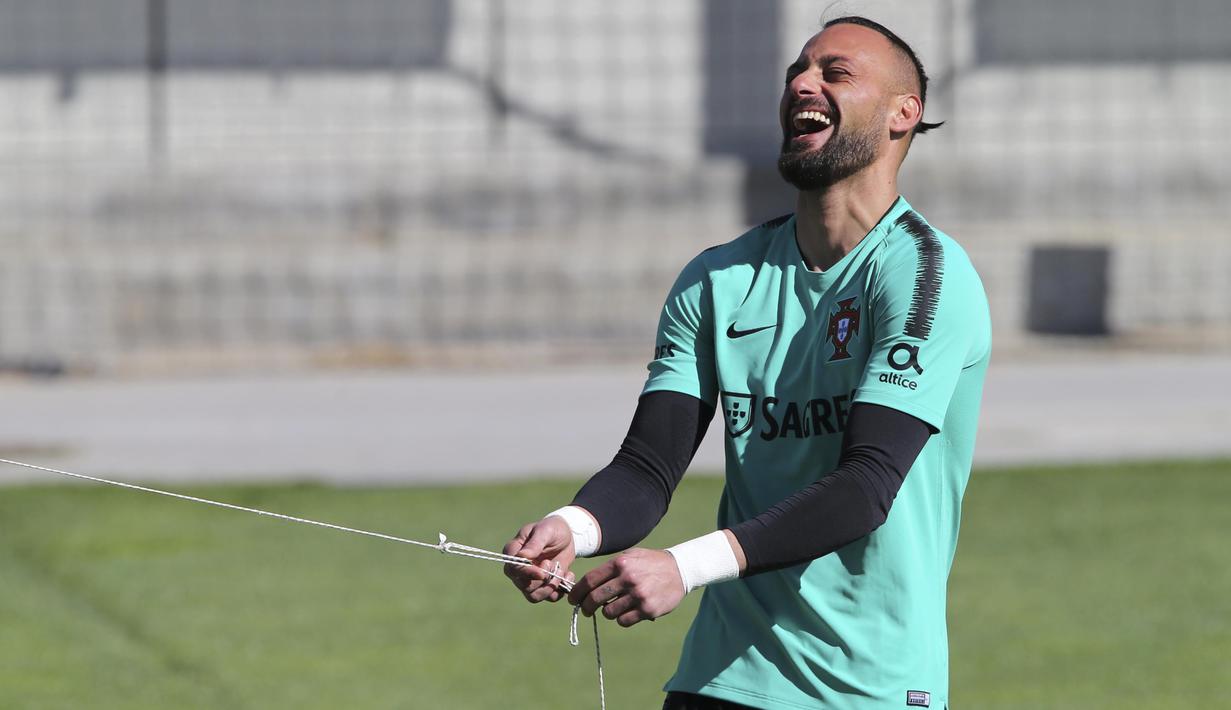 Kiper Portugal, Beto, tertawa saat latihan jelang laga kualifikasi Piala Eropa di Lisbon, Selasa (19/3). Portugal akan berhadapan dengan Ukraina. (AP/Armando Franca)