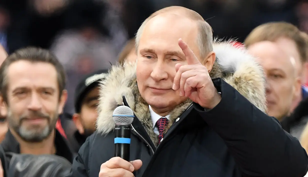 Kandidat presiden Rusia, Vladimir Putin memberikan pidato dalam kampanye pencalonannya di stadion Luzhniki di Moskow (3/3). Putin telah menjabat sebagai Presiden Rusia selama 3 periode, yakni 2000-2004, 2004-2008, dan 2012-2018. (AFP/Kirill Kudryavtsev)