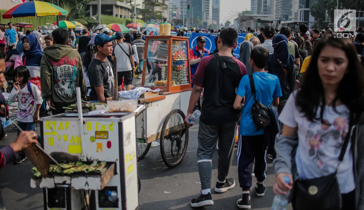 Warga melewati pedagang kaki lima (PKL) yang berjualan di kawasan car free day (CFD), Bundaran HI, Jakarta, Minggu (4/8/2019). Kurangnya pengawasan petugas menyebabkan banyak PKL berjualan tidak pada tempat yang telah disediakan oleh Pemprov DKI Jakarta. (Liputan6.com/Faizal Fanani)