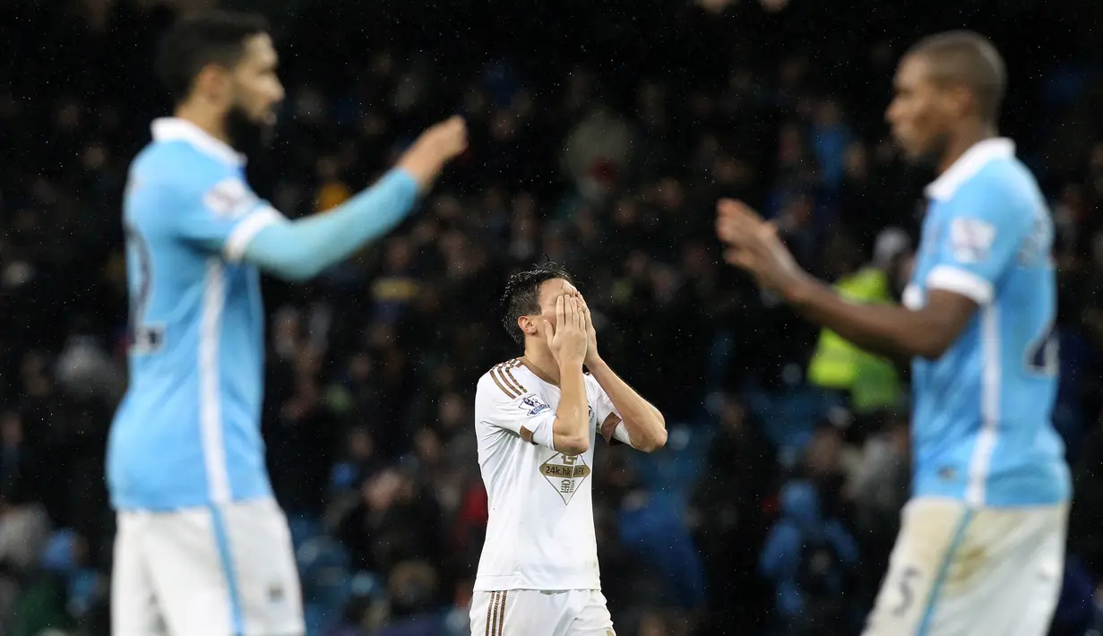 Ekspresi kekecewaan pemain Swansea City, Jack Cork (tengah), setelah kalah dari Manchester City dalam lanjutan Liga Inggris di Stadion Etihad, Manchester, Sabtu (12/12/2015). (AFP/Lindsey Parnaby)