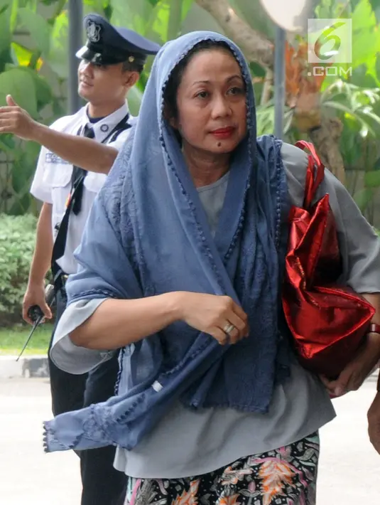 Ekspresi istri muda Bupati Bengkulu Selatan Dirwan Mahmud, Heni Dirwan tiba di Gedung KPK, Jakarta, Rabu (16/5). Heni turut diamankan dalam operasi tangkap tangan (OTT) KPK di rumah pribadi Bupati Bengkulu Selatan Dirwan Mahmud. (Merdeka.com/Dwi Narwoko)