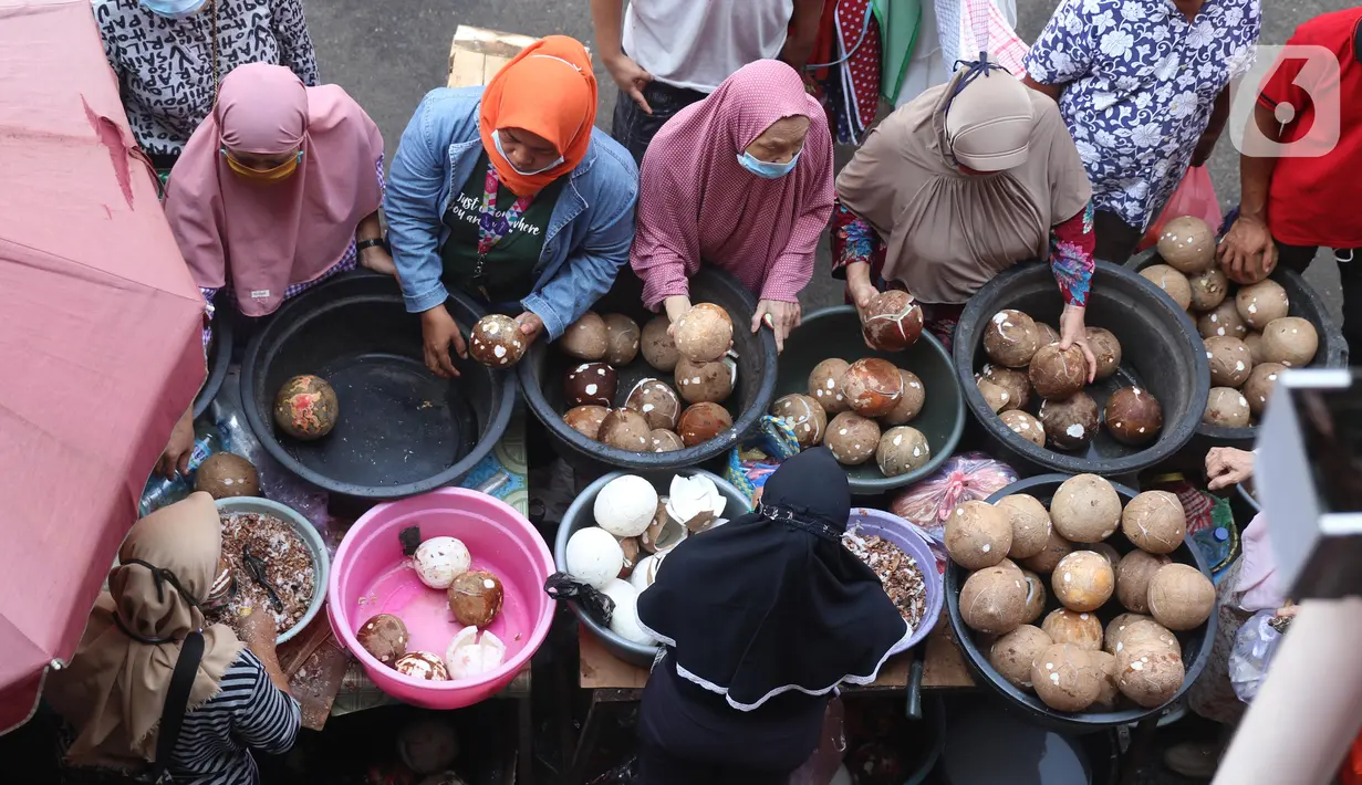 Pengunjung membeli kelapa untuk bahan makanan di pasar Kebayoran Lama, Jakarta, Selasa (11/5/2021). Warga memadati pasar tradisional demi memenuhi kebutuhan jelang Idul Fitri 1442 H. (Liputan6.com/Angga Yuniar)