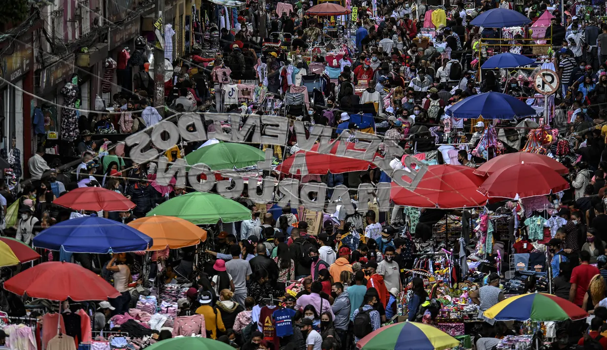 Jalan komersial di San Victorino dipenuhi oleh orang-orang yang berbelanja hadiah Natal di Bogota, Kolombia, Senin (21/12/2020). Kota-kota utama di Kolombia pada Senin mengumumkan pembatasan yang mempengaruhi sekitar 15 juta orang karena peningkatan penularan covid-19. (Juan BARRETO/AFP)