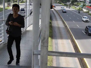 Pejalan kaki melintasi halte busway di Jalan Jenderal Sudirman, Jakarta, Selasa (5/2). Libur Tahun Baru Imlek 2019 menyebabkan ruas jalan protokol di Ibukota bebas dari kemacetan dibandingkan dengan hari biasa. (Liputan6.com/Immanuel Antonius)