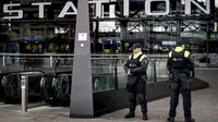 Aparat kepolisian berjaga di pintu masuk sebuah stasiun di Rotterdam, Senin (18/3). Pihak keamanan di Belanda meningkatkan keamanan di bandara dan bangunan penting lainnya usai penembakan di Utrecht yang menewaskan 3 orang.  (KOEN VAN WEEL/ANP/AFP)