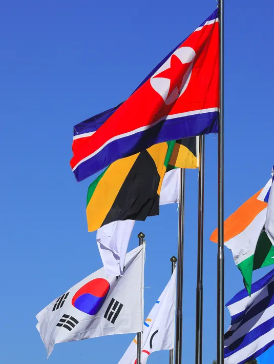 Bendera nasional Korea Utara berkibar bersama bendera negara-negara lain di desa atlet di Pyeongchang, Korea Selatan (1/2). Olimpiade Musim Dingin 2018 akan digelar antara tanggal 9 dan 25 Februari 2018. (AFP Photo/Yonhap)