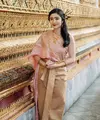 Ia mengenakan pakaian tradisional Thailand yang disebut dengan chut thai. Febby mengenakan chut thai atasan pink dipadukan bawahan mirip songket warna coklat. [Instagram/@febbyrastanty]