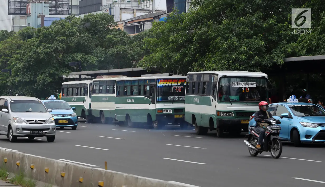 Bus Kopaja menunggu penumpang di Jalan Jenderal Sudirman, Jakarta, Rabu (4/7). Wagub DKI Jakarta Sandiaga Uno melarang angkutan umum seperti Kopaja dan Metromini melintasi jalan protokol selama Asian Games 2018. (Liputan6.com/Arya Manggala)