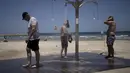 <p>Para pria mandi di pantai umum saat mereka mendinginkan diri dari gelombang panas di Tel Aviv, Israel, Kamis (13/7/2023). Menurut laporan berita lokal pada hari Rabu, Badan Meteorologi Israel telah mengeluarkan peringatan panas yang parah tentang risiko dehidrasi dan serangan panas. (AP Photo/Maya Alleruzzo)</p>