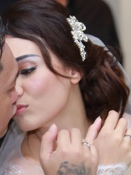 Franky Sihombing mengecup bibir sang istri dengan mesra sebagai pasangan suami istri, setelah resmi menikah keduanya tentu siap berbulan madu. Namun lokasi bulan madunya masih dirahasiakan. (Galih W. Satria/Bintang.com)