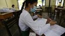 Seorang siswa yang mengenakan masker mengisi formulir informasi pribadi pada hari pendaftaran sekolah di Yangon, Myanmar (13/7/2020). Myanmar sejak Selasa (7/7) memulai pendaftaran sekolah untuk tahun ajaran 2020-2021, yang tertunda akibat pandemi COVID-19. (Xinhua/U Aung)