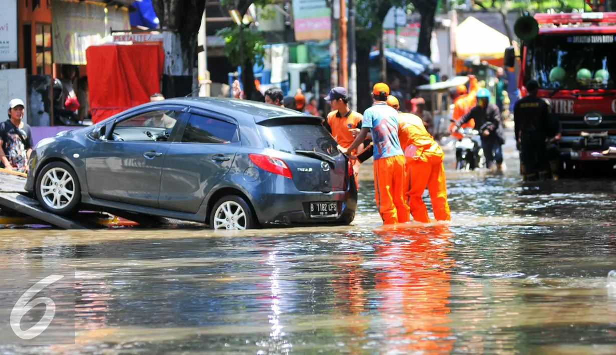 Sebuah mobil terpaksa dinaikan ke mobil derek akibat mogok karena menerobos banjir di jalan Pejaten Raya, Jakarta Selatan, Kamis (21/4/2016). Akibat banjir, kemacetan panjang terjadi di Jalan Pejaten Raya. (Liputan6.com/Yoppy Renato)