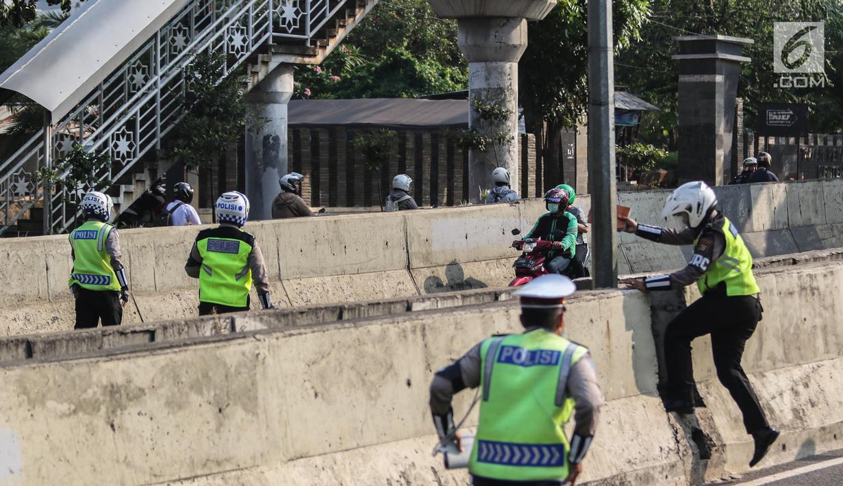 Petugas kepolisian berusaha memberhentikan pengemudi ojek online yang melintasi JLNT Kampung Melayu-Tanah Abang, Jakarta, Selasa (25/7). Sepeda motor dilarang melintas di JLNT tersebut karena merupakan jalur cepat. (Liputan6.com/Faizal Fanani)