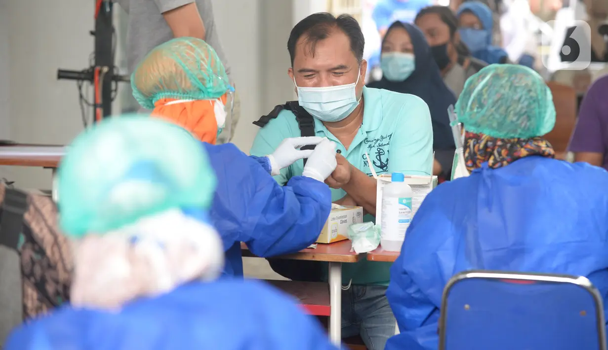 Petugas kesehatan mengambil sampel darah anggota KPPS saat rapid test Covid-19 di kantor Kelurahan Pondok Benda, Tangerang Selatan, Jumat (27/11/2020). Rapid test dilakukan guna mengantisipasi penyebaran Covid-19 saat pemungutan suara Pilkada Kota Tangerang Selatan 2020. (merdeka.com/Dwi Narwoko)