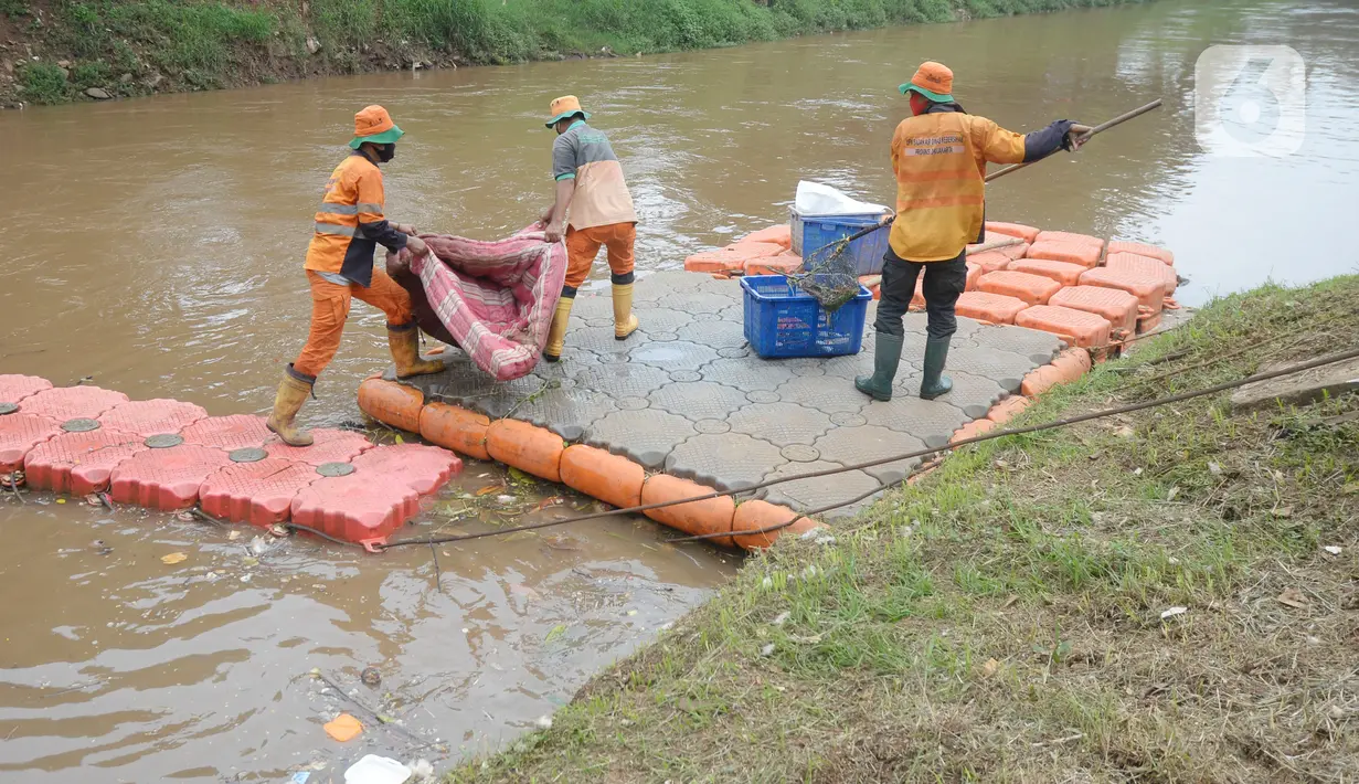Pekerja Dinas Kebersihan mengangkat sampah kasur di Kali Pesanggrahan, Jakarta Selatan, Rabu (4/11/2020). Sampah-sampah yang terbawa arus air terjaring di penyaringan sampah yang dipasang untuk mengantisipasi penyumbatan pada musim penghujan bisa terjadi banjir. (merdeka.com/Dwi Narwoko)