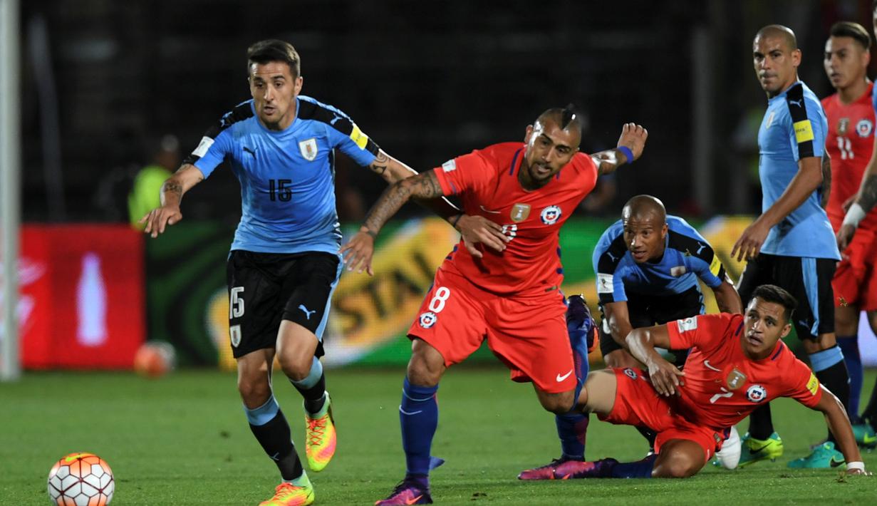 Pemain Cile, Arturo Vidal dan Alexis Sanchez, berebut bola dengan pemain Uruguay pada laga Kualifikasi Piala Dunia 2018 zona CONMEBOL di Stadion Nasional Julio Martinez Pradanos, Santiago, Rabu (16/11/2016) pagi WIB. (AFP/Martin Bernetti)