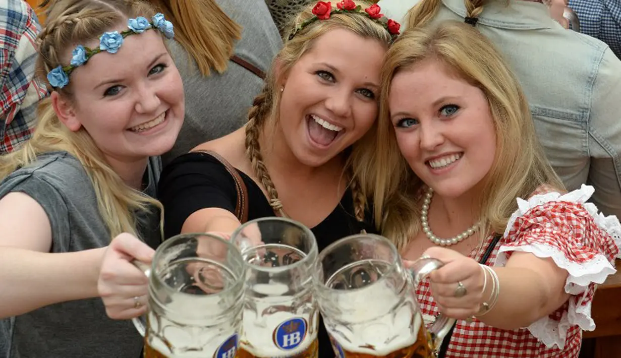 Pengunjung Festival Bir Oktoberfest berpose usai pembukaan festival di Munich, Jerman (19/9/2015). Oktoberfest di Jerman adalah festival bir terbesar di dunia yang akan berlangsung hingga 4 Oktober 2015. (AFP Photo / Christof stache) 