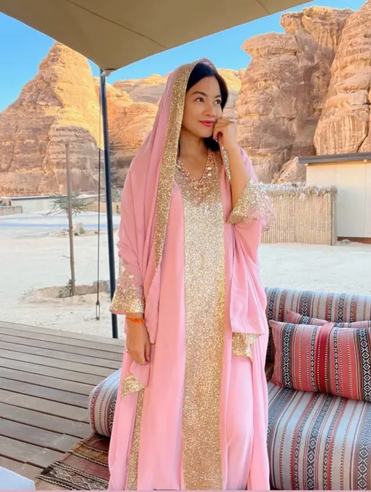 Gamis tersebut dipadukan dengan pashmina dengan warna serasi dan aksen emas. Dikenakan di atas rambut hitamnya.  [@titi_kamall]