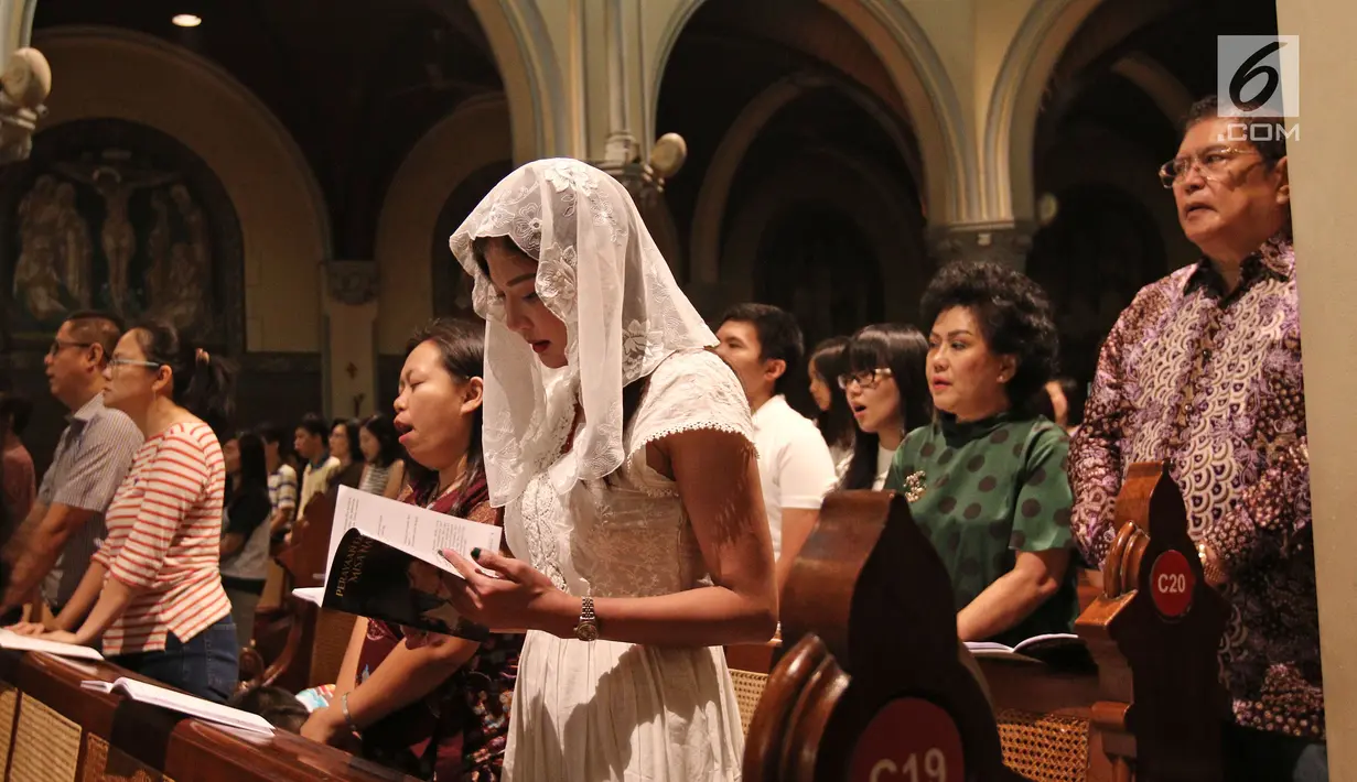 Umat Nasrani terlihat khusyuk berdoa saat mengikuti Misa Natal di Gereja Katedral, Jakarta, Minggu (24/12). Dalam perayaan Natal ini dekorasi di area Gereja Katedral juga disesuaikan dengan tema tersebut. (Liputan6.com/Herman Zakharia)