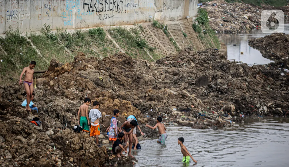 Anak-anak bermain di Sungai Ciliwung yang surut di kawasan Bukit Duri, Jakarta, Sabtu (8/8/2020). Penyusutan debit air Sungai Ciliwung tersebut karena memasuki masa kemarau 2020 yang menurut BMKG akan mencapai puncaknya pada Agustus. (Liputan6.com/Faizal Fanani)