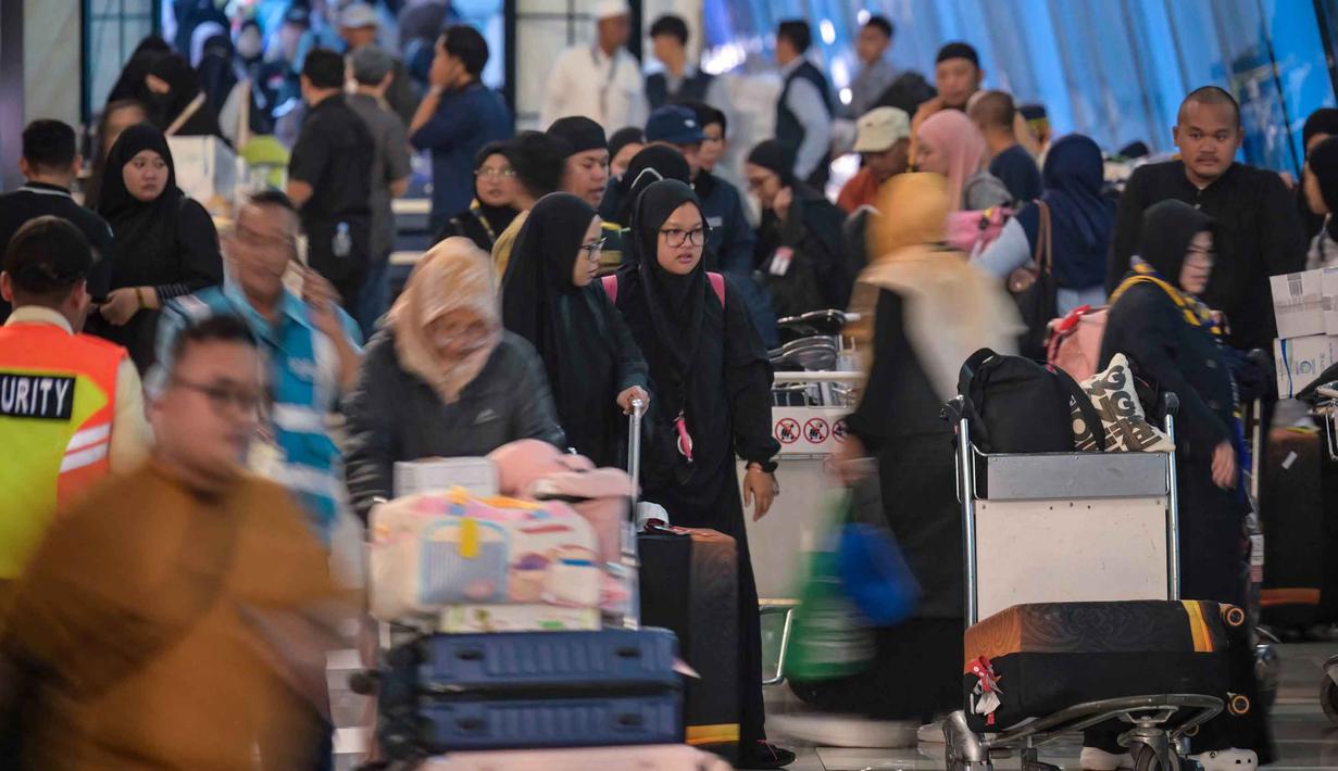 Selain itu, Bandara Internasional Soekarno-Hatta, Tangerang, Banten, pada Selasa 10 Maret 2026, juga kedatangan para WNI yang kembali ke tanah air usai menjalani ibadah umrah. Tampak dalam foto, umat Muslim Indonesia yang kembali usai menunaikan ibadah Umrah tiba di Bandara Internasional Soekarno-Hatta, Tangerang, Banten, pada Selasa 10 Maret 2026. (BAY ISMOYO/AFP)