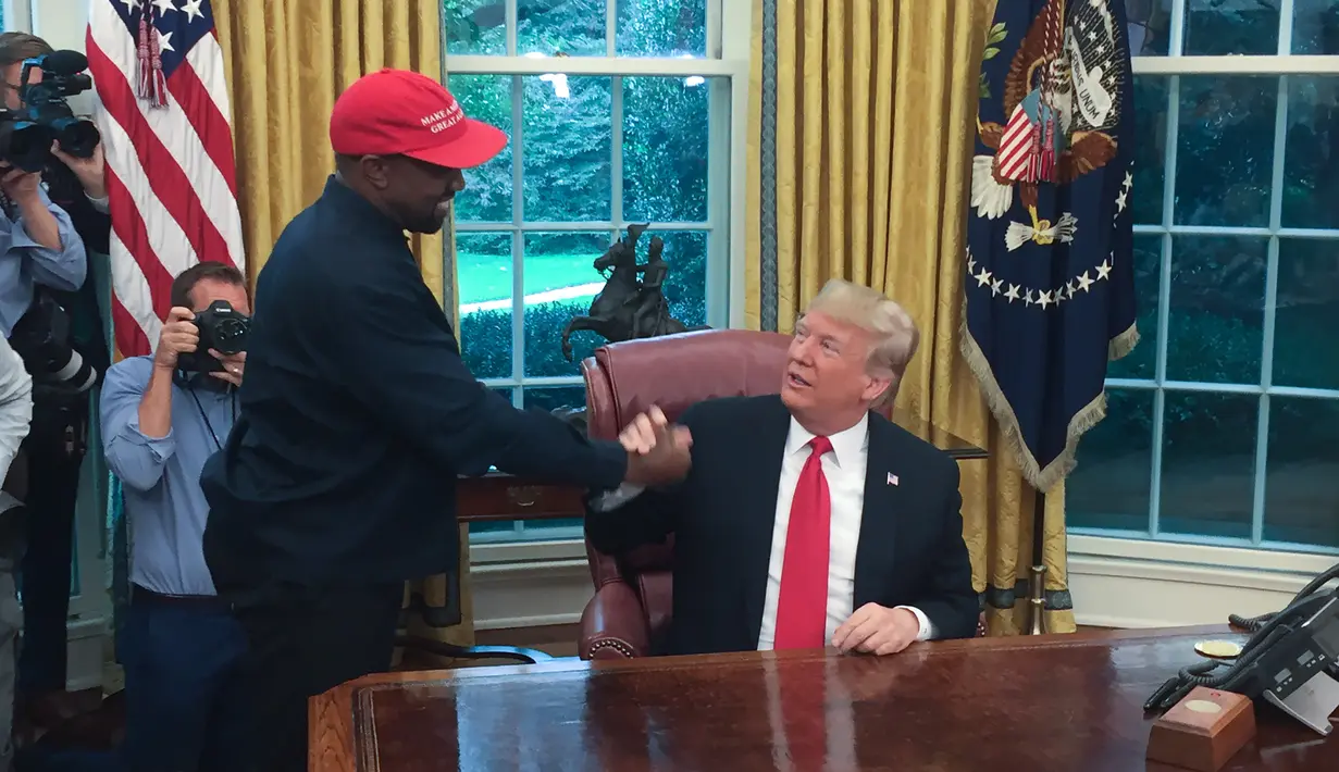 Presiden AS, Donald Trump bertemu dengan rapper Kanye West di Oval Office, Gedung Putih, Kamis (11/10). Kali ini, pertemuan Trump dan Kanye West untuk membahas ketersediaan lapangan kerja bagi mantan narapidana. (SEBASTIAN SMITH / AFP)