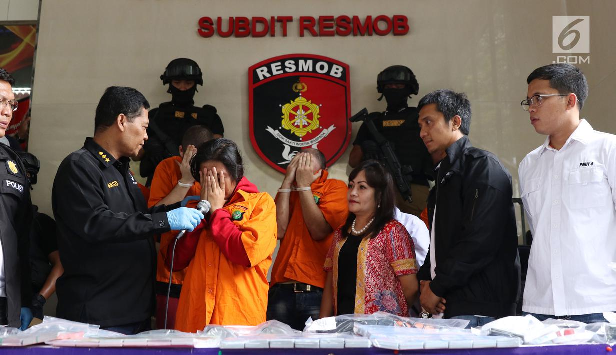 Kabid Humas Polda Metro Jaya Kombes Pol Argo Yuwono menginterograsi salah satu tersangka pembobol uang dari mesin ATM dengan teknik skimming saat rilis di Jakarta, Sabtu (17/3). Kasus melibatkan empat WNA dan seorang WNI. (Liputan6.com/Helmi Fithriansyah)