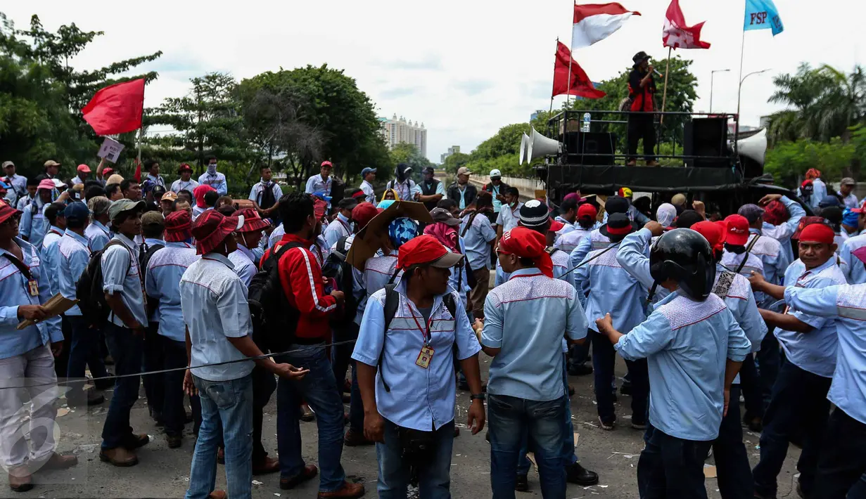 AMT (Awak Mobil Tangki) menyampaikan tuntutan mereka saat melakukan mogok kerja dan unjuk rasa di Depot Pertamina Plumpang Jakarta, Selasa (1/11). Massa menuntut perusahaan menghapus sistem outsourcing dan membayar upah lembur (Liputan6.com/Faizal Fanani)