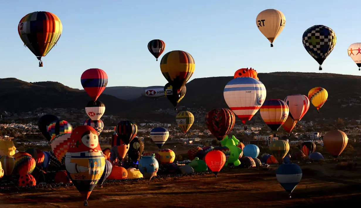 Beragam balon udara dengan bentuk bentuk soda, hewan, dan boneka menghiasi udara. (ULISES RUIZ/AFP)
