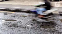 Pengendara sepeda motor maupun mobil yang melintas harus ekstra hati-hati, terutama pada malam hari, mengingat kurangnya penerangan di area yang rusak. (Magang/Liputan6.com/Muhammad Rizal)