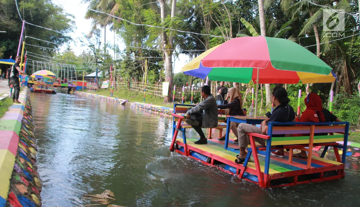 Wisatawan menaiki perahu apung di Wisata Air Toino, Desa Talulobutu, Kecamatan Tapa, Kabupaten Bone Bolango, Gorontalo, Sabtu (30/3). Kendati baru, tempat wisata buatan ini mulai diminati banyak wisatawan. (Liputan6.com/Arfandi Ibrahim)