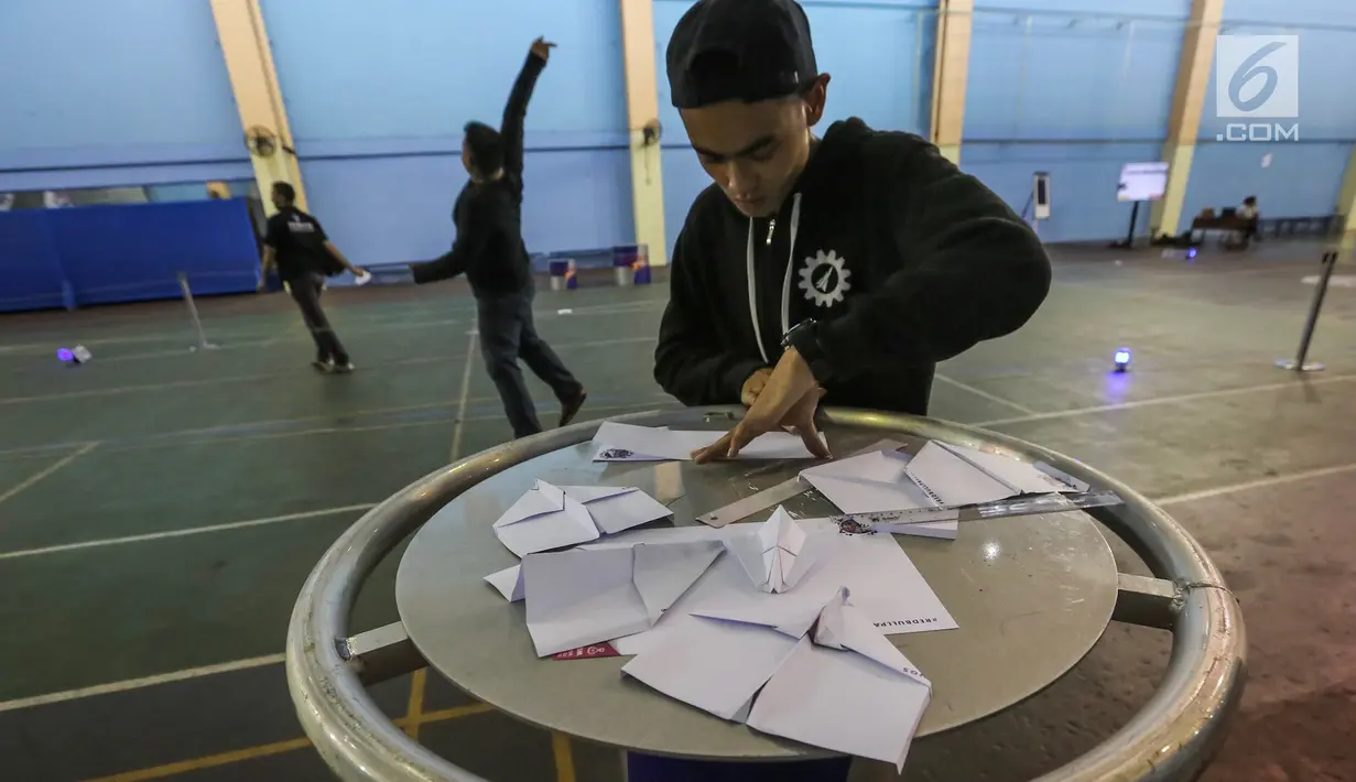Peserta melipat pesawat kertas pada kompetisi final Red Bull Paper Wings 2019 di Universitas Tarumanagara, Jakarta, Jumat (5/4). Sebanyak 20 pilot telah terpilih pada babak kualifikasi yang telah diadakan pada tanggal 20 Februari dan 13 Maret. (Liputan6.com/Fery Pradolo)