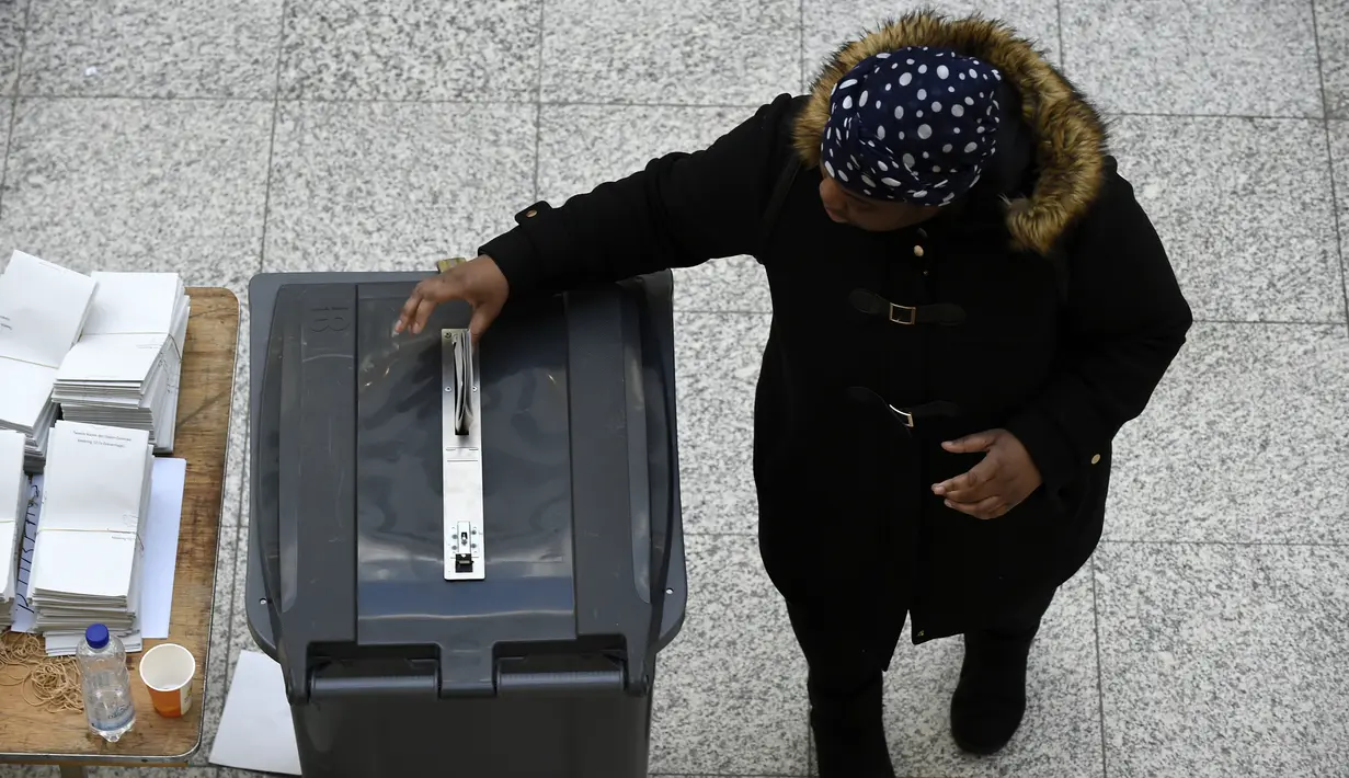 Seorang pria memasukkan surat suara ke tempat sampah yang disulap menjadi kotak suara saat pemilihan umum Belanda di sebuah TPS di Den Haag, Rabu (15/3). Pemilu ini untuk menentukan siapa perdana menteri Belanda selanjutnya (JOHN THYS/AFP)