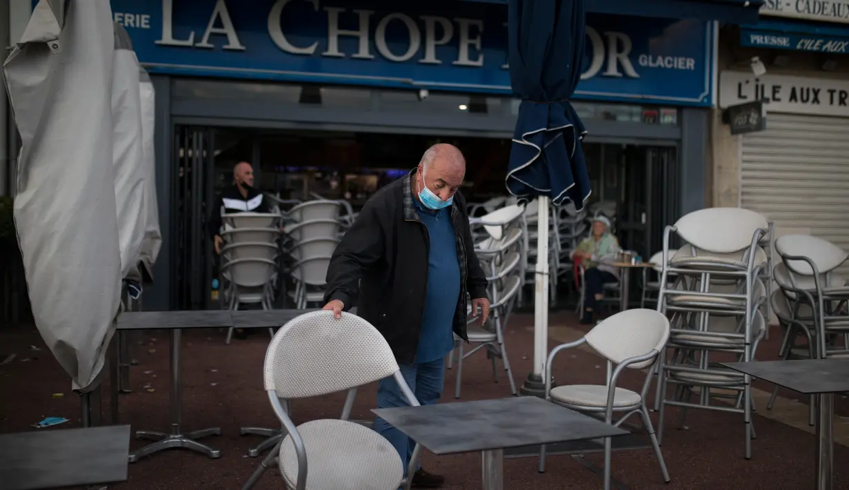 Marc Magere menutup restorannya di Marseille, selatan Prancis, Minggu (27/9/2020). Restoran dan bar di Marseille pada hari Minggu bersiap tutup selama sepekan sebagai bagian dari pembatasan baru baru Covid-19. (AP Photo/Daniel Cole)