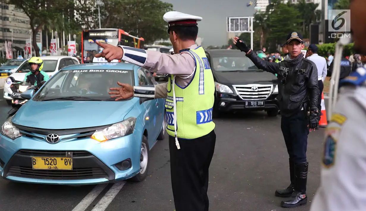 Polisi dan Dishub mengatur lalu lintas di Senayan, Jakarta, Minggu (2/9). Untuk meminimalisasi kemacetan jelang penutupan Asian Games 2018, rekayasa lalu lintas dilakukan di sejumlah ruas jalan dari dan menuji Senayan. (Liputan6.com/Immanuel Antonius)