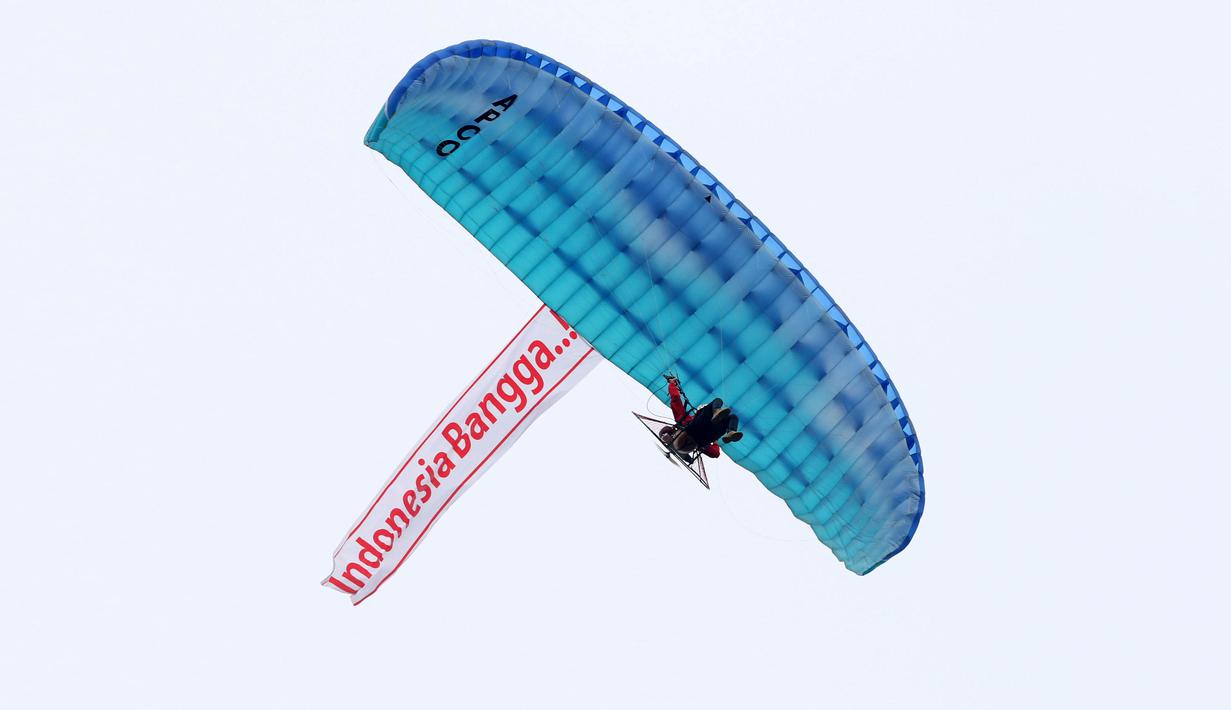 Aksi paramotor yang terbang membawa slogan 'Indonesia Bangga..!' pada peluncuran Logo Asian Games 18th di Senayan, jakarta, Sabtu (27/12/2015). (Bola.com/Nicklas Hanoatubun) 