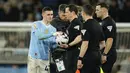 Gelandang Manchester City, Phil Foden yang sukses mencetak hattrick mengambil bola dari wasit setelah berakhirnya laga pekan ke-31 Premier League 2023/2024 menghadapi Aston Villa di Etihad Stadium, Manchester, Rabu (3/4/2024) malam. (AP Photo/Dave Thompson)