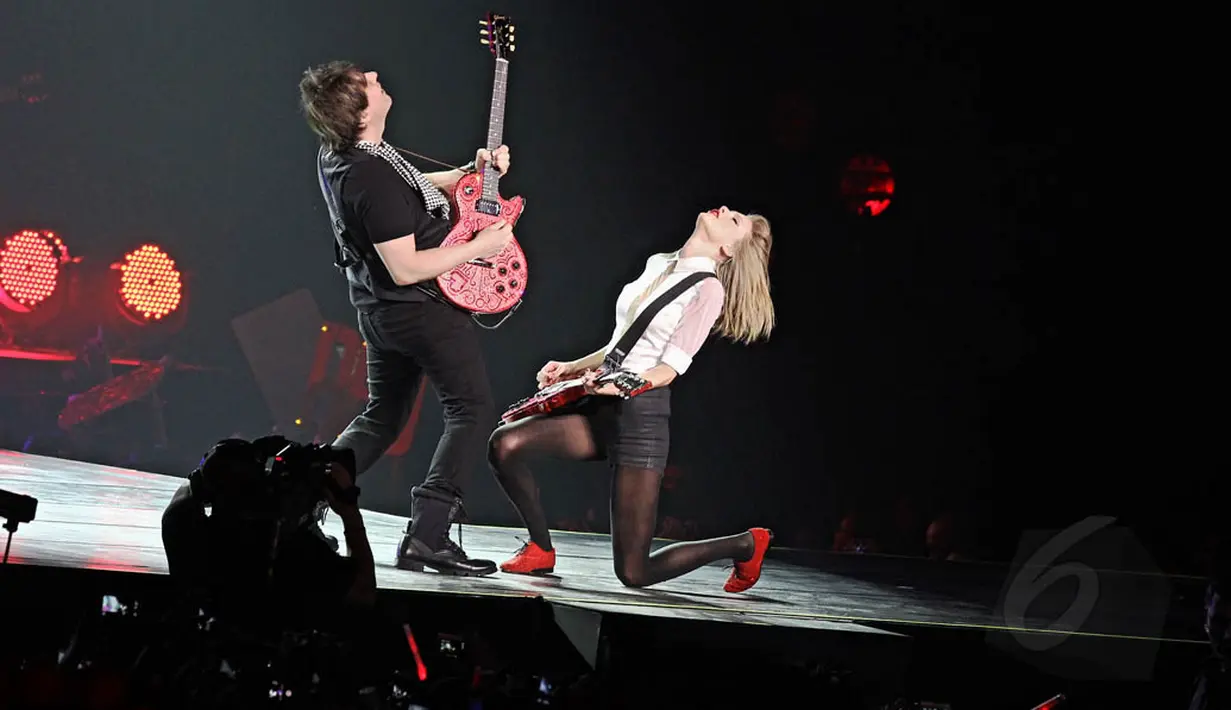 Taylor Swift pun unjuk kebolehan dalam bermain gitar sambil bernyanyi saat mendendangkan lagu 'Red' (Liputan6.com/Faizal Fanani)