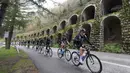 Peserta balap Tour of Catalonia cycling race melintasi sebuah daerah yang terlihat seperti benteng  di Calella, Senin (21/3/2016. (AFP/Josep Lago)