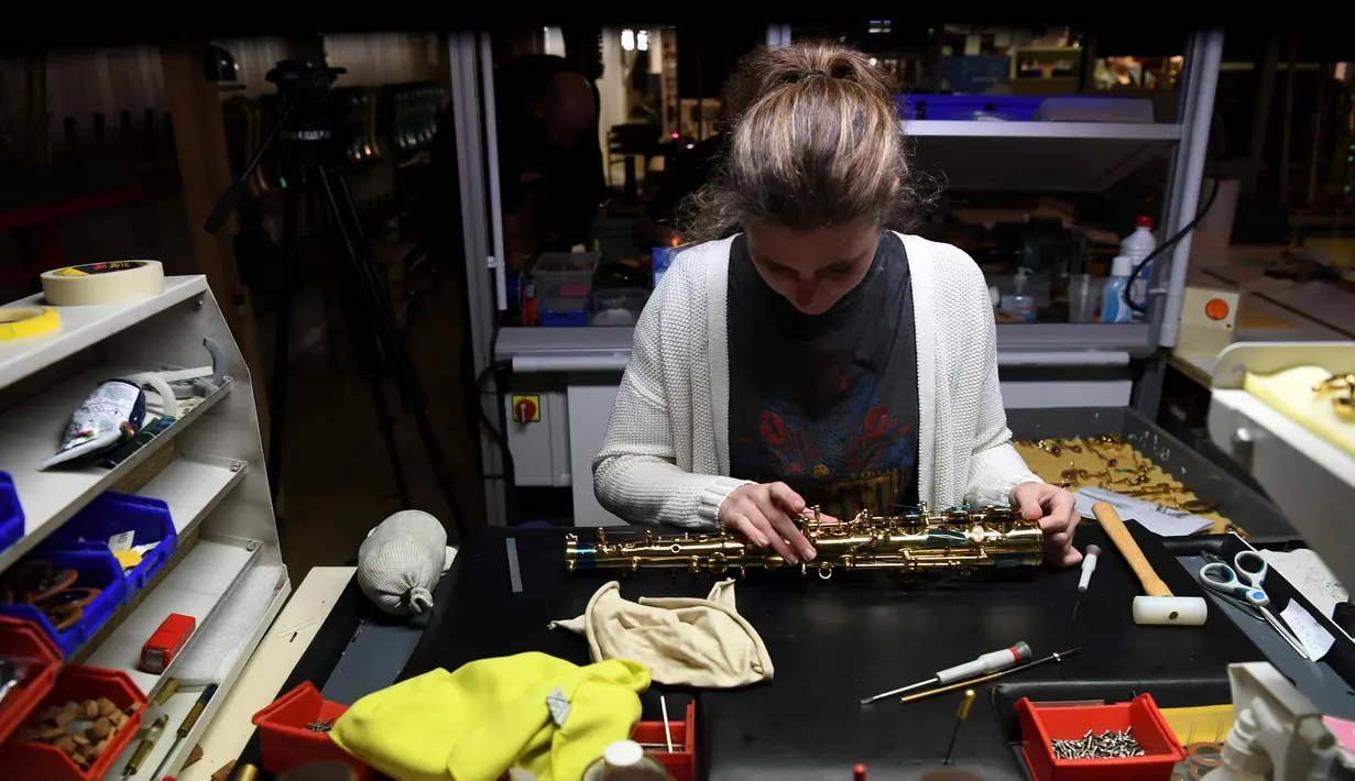 Pekerja mengecek bagian key finger button pada saksofon di pabrik Selmer Saxophone di Mantes-la-Ville (17/1). Saksofon umumnya dihubungkan dengan popular music, big band music dan jazz, sebagai instrumen orkestra dan band militer. (AFP Photo/Alain Jocard)