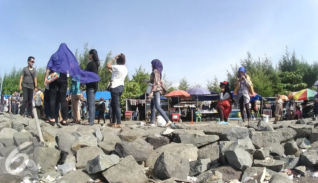 Sejumlah pengunjung saat berada di Pantai Alam Indah saat libur lebaran, Tegal, Jawa Tengah, Minggu (10/7). Pantai Alam Indah bukan hanya didatangi warga lokal tetapi para pemudik juga mengunjungi tempat ini. (Liputan6.com/Herman Zakharia)