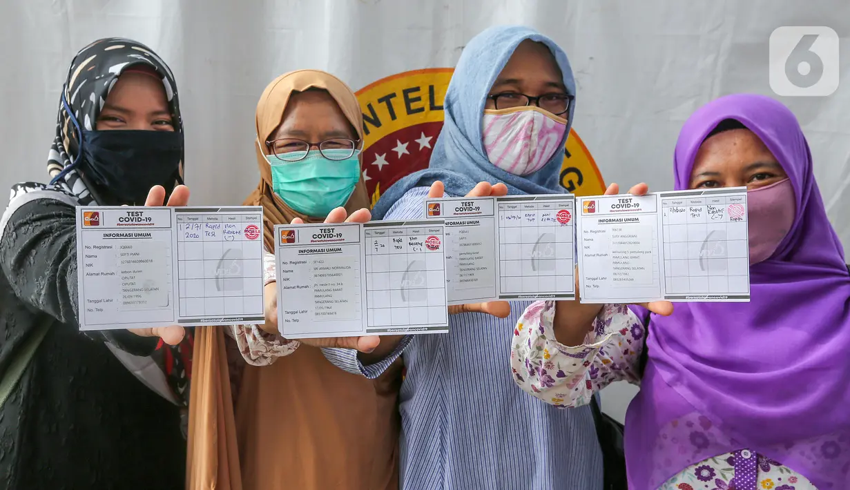 Warga menunjukkan kartu hasil rapid test massal Badan Intelijen Negara (BIN) di lapangan Pamulang, Tangerang Selatan, Kamis (2/7/2020). Tiga wilayah kelurahan dengan angka kasus positif Covid-19 tertinggi yakni di Pamulang Timur, Jurangmangu Barat, dan Pondok Betung. (Liputan6.com/Fery Pradolo)