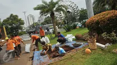 Pekerja mengangkut tanah saat pembuatan sumur resapan di Monas, Jakarta, Jumat (22/7). Pembuatan puluhan sumur resapan itu guna mengantisipasi genangan air hujan dan menyimpan air di Kawasan Monas dan depan Istana Merdeka. (Liputan6.com/Gempur M Surya)