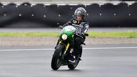 Jokowi mengendarai motor custom dengan warna hijau garapan Katros Garage. Dia mengenakan setelan jaket hitam dan sepatu sneakers saat menjajal sirkuit Mandalika. (Istana Kepresidenan/Agus Suparto)
