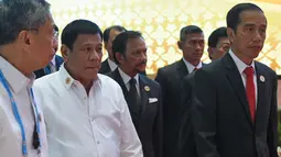 Presiden Filipina Rodrigo Duterte dan Presiden Indonesia Joko Widodo berjalan menuju tempat sidang paripurna KTT ASEAN di Vientiane (6/9). (AFP PHOTO/Roslan Rahman)