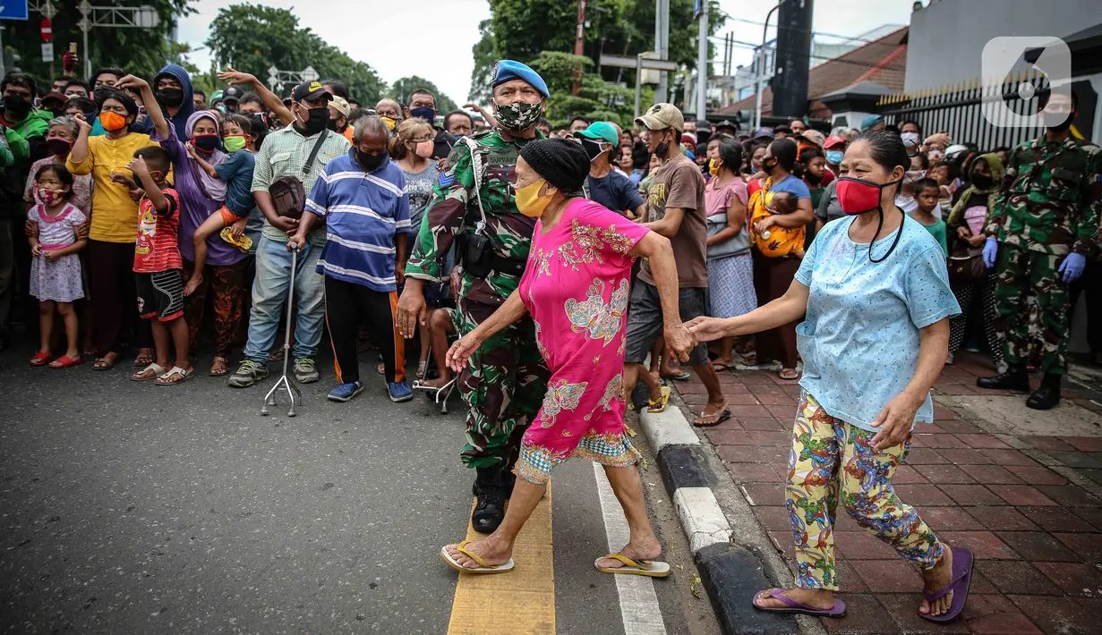 Warga mengantre nasi kotak serta masker dari TNI di Markas Komando Gabungan Wilayah I, Jakarta, Selasa (21/4/2020). Dalam rangka Hari Kartini, TNI membagikan makanan dan masker kepada masyarakat. (Liputan6.com/Faizal Fanani)