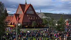 Orang-orang berkumpul untuk menyaksikan pemindahan Gereja Kayu Kiruna di Kiruna, Swedia, pada 19 Agustus 2025. (Jonathan Nackstrand/AFP)