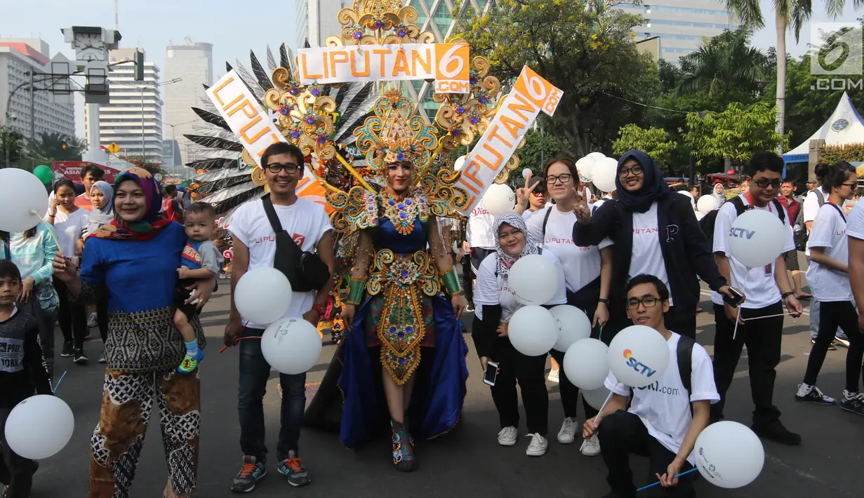 Karyawan PT Elang Mahkota Teknologi (Emtek) menjadi peserta parade Asian Games 2018 di Jalan Thamrin, Jakarta, Minggu (13/5). Perwakilan Emtek menggunakan kaos putih sambil membawa balon-balon putih. (Liputan6.com/Arya Manggala)
